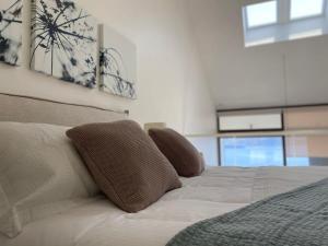 ein Schlafzimmer mit einem Bett mit zwei Kissen darauf in der Unterkunft HOM I EnValparaiso, Loft Ubicado en MiradorBarón Parking 1613 in Valparaíso