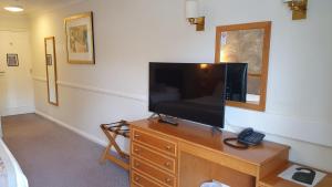 a television on a wooden dresser in a room at Alton House Hotel in Alton