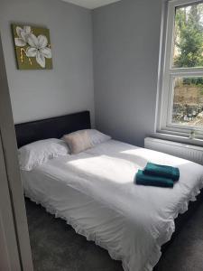- un lit avec 2 serviettes dans une chambre dans l'établissement Cosy 2 Bedroom House, à Kent