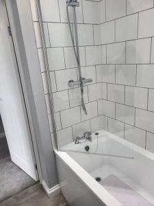 La salle de bains est pourvue d'une douche, d'une baignoire et d'un lavabo. dans l'établissement Cosy 2 Bedroom House, à Kent