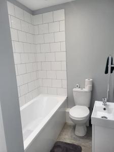 La salle de bains est pourvue de toilettes, d'une baignoire et d'un lavabo. dans l'établissement Cosy 2 Bedroom House, à Kent