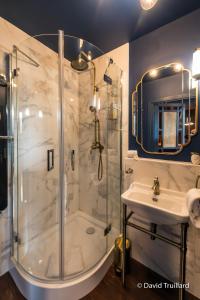 La salle de bains est pourvue d'une douche et d'un lavabo. dans l'établissement Suites Mana- Le Boudoir Art Déco 4* Place Ducale Parking inclus, à Charleville-Mézières
