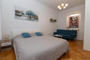a bedroom with a bed and a blue couch at Teatro apartment in Rijeka