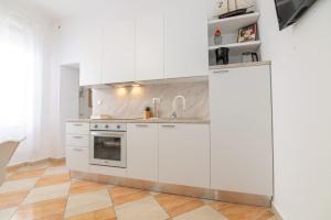 a kitchen with white cabinets and a sink at Teatro apartment in Rijeka
