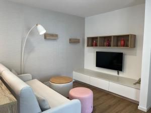 a living room with a couch and a tv at Apartamentos Atalaya de Jandía by LIVVO in Morro del Jable