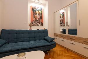 a living room with a blue couch and a mirror at Teatro apartment in Rijeka