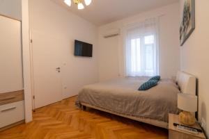 a bedroom with a large bed and a window at Teatro apartment in Rijeka +6 photos