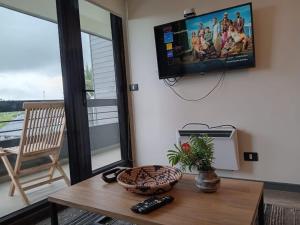 uma sala de estar com uma mesa e uma televisão na parede em ENCANTADOR Depto en la Mejor Ubicación de PtoVaras em Puerto Varas