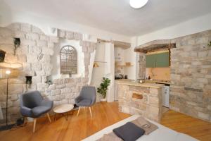 a living room with two chairs and a stone wall at Charming apartment in Kotor in Kotor