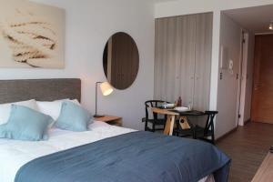 una camera da letto con un letto e un tavolo con una sedia di HOM I Departamento Estudio en Mejor Zona Frente al Mall 1218 ad Antofagasta