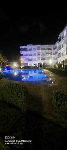 a swimming pool in front of a building at night at Mansbay beach in Aïn Harrouda