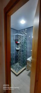 La salle de bains est pourvue d'une douche en verre et d'un lavabo. dans l'établissement Mansbay beach, à Aïn Harrouda