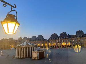 een straatlicht met een gebouw op de achtergrond bij Suites Mana- Le Boudoir Art Déco 4* Place Ducale Parking inclus in Charleville-Mézières