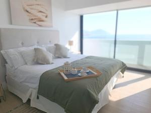 Un dormitorio con una cama y una bandeja. en Depto 1D1B Frente al Mall con Terraza Vista al Mar Servicio HOM 2312, en Antofagasta