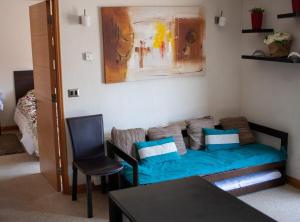 uma sala de estar com um sofá azul e uma mesa em 6PAX Edificio Valle Cóndores SKI OUT Valle Nevado Servicio HOM em Santiago