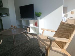 sala de estar con mesa y TV en Depto 1D1B Frente al Mall con Terraza Vista al Mar Servicio HOM 2312, en Antofagasta