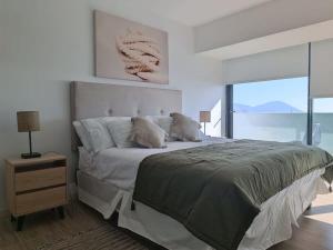 biała sypialnia z dużym łóżkiem i oknem w obiekcie Depto 1D1B Frente al Mall con Terraza Vista al Mar Servicio HOM 2312 w mieście Antofagasta