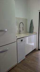 a kitchen with white appliances and a sink at La Esquina in Denia