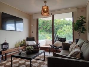 uma sala de estar com um sofá e uma mesa em Espectacular Depto 2D2B Frente al Lago y Parking Servicio HOM em Puerto Varas