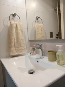 uma casa de banho com um lavatório branco e um espelho. em Espectacular Depto 2D2B Frente al Lago y Parking Servicio HOM em Puerto Varas