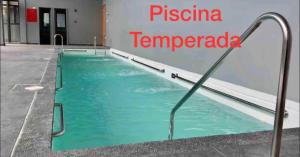 a swimming pool with blue water in a building at Precioso y acogedor depto 1D1B con Parking y Piscina Temperada HOM in Puerto Varas