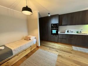 a small room with a bed and a kitchen at Precioso y acogedor depto 1D1B con Parking y Piscina Temperada HOM in Puerto Varas
