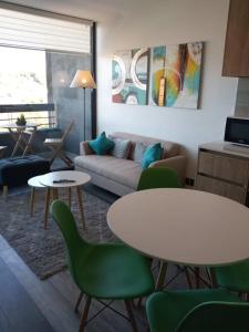 uma sala de estar com um sofá, uma mesa e cadeiras em Cómodo Depto Nuevo en la Mejor Zona de Pto Varas Servicio HOM em Puerto Varas