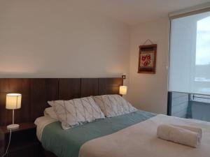 Un dormitorio con una cama grande y una ventana en Cómodo Depto Nuevo en la Mejor Zona de Pto Varas Servicio HOM en Puerto Varas