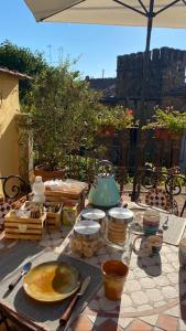 een tafel met borden en keukengerei op een patio bij La Terrazza sul Borgo - Montefioralle Apartment in Greve in Chianti