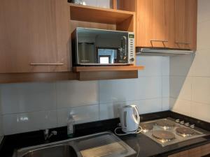 a kitchen with a microwave above a sink at Estudio Edif valle Cóndores en valle Nevado SKIOUT Servicio HOM in Lo Barnechea