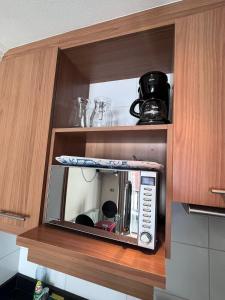 a microwave in a cabinet in a kitchen at Estudio Edif valle Cóndores en valle Nevado SKIOUT Servicio HOM in Lo Barnechea