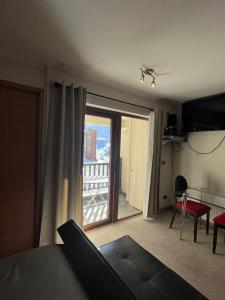 a bedroom with a bed and a view of a balcony at Estudio Edif valle Cóndores en valle Nevado SKIOUT Servicio HOM in Lo Barnechea