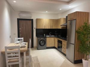 a kitchen with a table and a stove and a refrigerator at Modernité Au cœur du parc de Mohammedia in Mohammedia