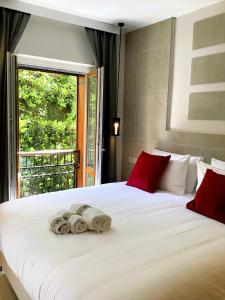 a bedroom with a large white bed with red pillows at Su Coru 2 - Deluxe Studio in the Heart of Cagliari in Cagliari