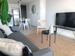 sala de estar con sofá y TV en Dúplex con Terraza y Parking con vista al MarHOM 1118 en Antofagasta