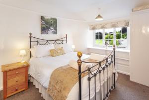 une chambre avec un lit et deux fenêtres dans l'établissement Crown Cottage Exford, à Exford