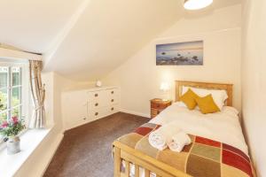 une chambre avec un lit et une fenêtre dans l'établissement Crown Cottage Exford, à Exford