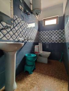 een blauwe badkamer met een wastafel en een toilet bij Badrinath Guest House in Badrīnāth