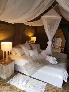 a bedroom with a large bed with a canopy at Kruger Untamed - Satara Plains Camp 