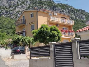 a yellow house with a fence in front of it at Apartment in Bribir 15452 in Bribir