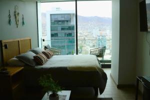 1 dormitorio con cama y ventana grande en Acogedor depto Home estudio ServicioHOM 0516, en Antofagasta