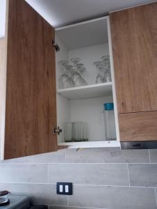 uma cozinha com um armário aberto com pratos em PRECIOSO Depto 1D1B en Pto Varas con parking Servicio HOM em Puerto Varas