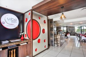 un ristorante con un cartello rosso e bianco sul muro di Holiday Inn Express Sandton-Woodmead, an IHG Hotel a Johannesburg