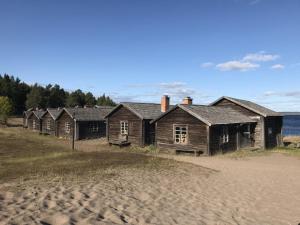 Ulvöhamn的住宿－Sandvikens Fiskeläge Ulvön，海滩上一排古老的木屋