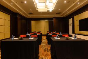 a conference room with black tables and red chairs at Crowne Plaza Nairobi Airport by IHG in Nairobi