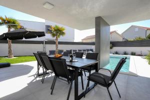 a dining room with a table and chairs on a patio at Villa Didov San Family Residence with Pool in Zaton