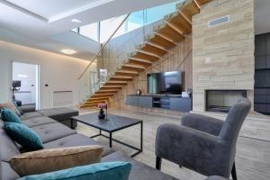 a living room with a couch and a staircase at Villa Didov San Family Residence with Pool in Zaton