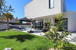 a backyard of a house with a patio and grass at Villa Didov San Family Residence with Pool in Zaton