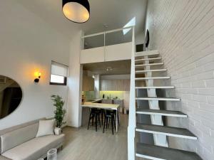 バルパライソにあるHOM I Lujoso Loft con Mejor vista de Valparaíso, Parkingの白いレンガの壁の隣にあるリビングルームの階段