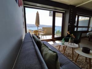バルパライソにあるHOM I Acogedor 2D2B, En Cerro Barón con estacionamientoの青いソファと大きな窓のあるリビングルーム